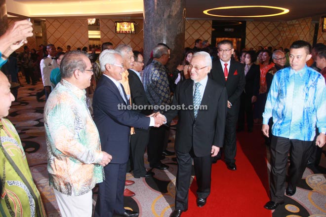 Taib greets guests on arrival at the dinner. Behind him is Jahar. 