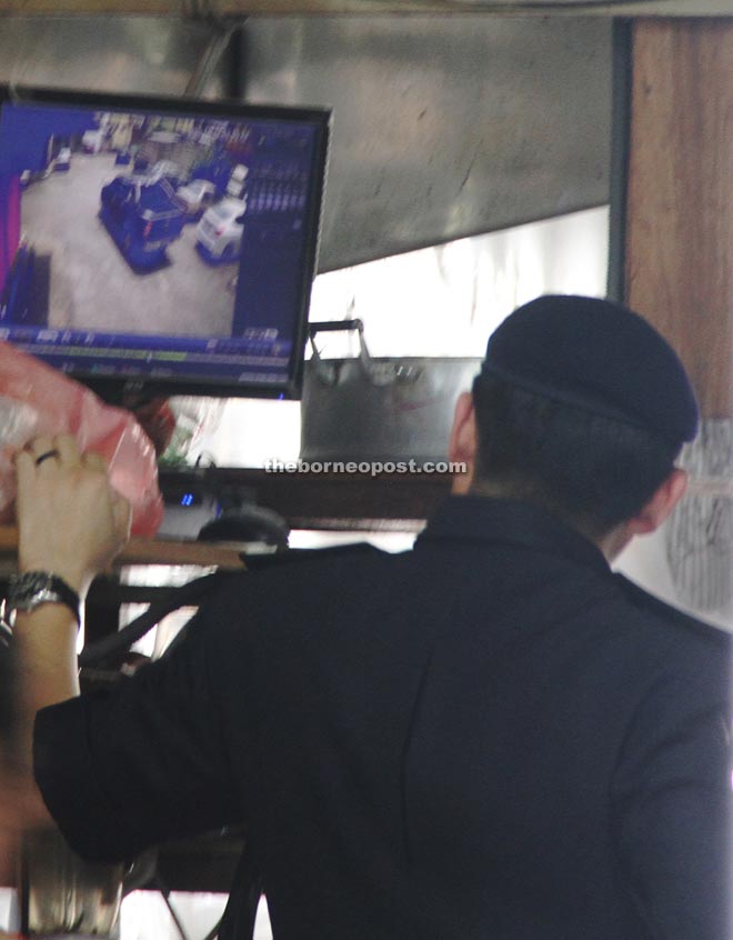 DSP Lim views the CCTV footage showing the arrival of the pickup truck.