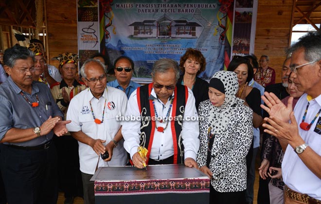 Adenan, flanked by Jamilah and Jabu, signing the plaque to officially recognise Bario as a sub-district after launching the annual Nukunen Festival. — Penerangan Photo.