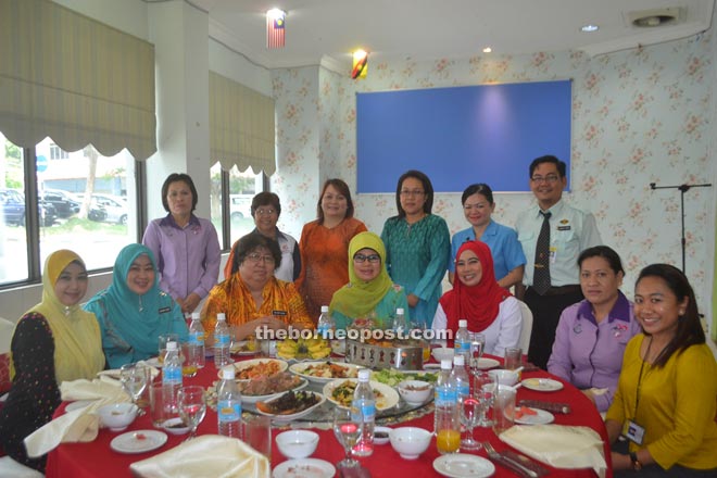 Fatimah (seated centre) is seen during a photo call with programme coordinators. 