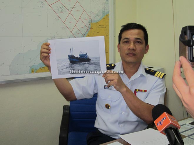 Syed Nor Adli shows a photograph of the seized vessel. 