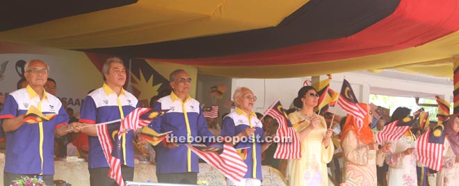 The dignitaries waving the Jalur Gemilang on the VVIP stand. 