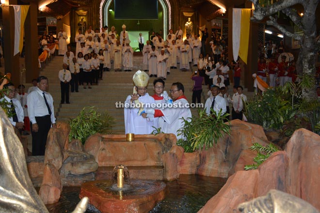 The blessing of the water by Bishop Hii in front of Sacred Heart Cathedral.