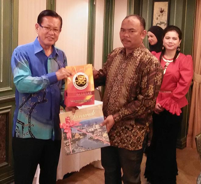Lee presents a souvenir to Pahang Youth and Sports exco chairman Johari at the dinner in Kuching. 