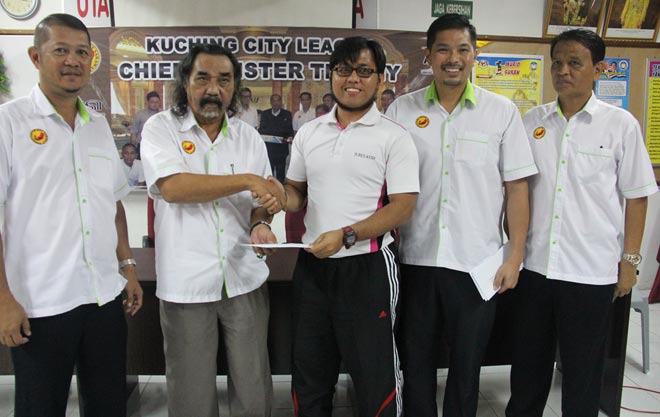 Awang Mahyan (second left) presents the grant to SM Sains Kuching teacher/coach Yusriazmi Yusof while (from left) state coach Chew Pok Cheong, SCA secretary Gordon Chung and Kuching District Education Office sports unit officer Mohd Rashid Ibrahim look on.