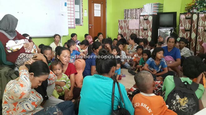 Some of the 97 illegal immigrants, including children and infants,  who were detained at the Immigration office yesterday. 