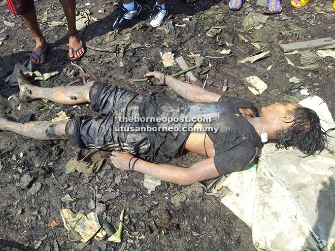 The victim's body at the scene in Kampung Bakau yesterday.