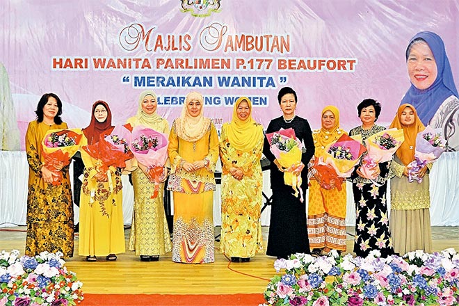 ANUGERAH: Norlida (empat kiri) dan Azizah (tengah) merakamkan gambar bersama sebahagian penerima anugerah pada Sambutan Hari Wanita di Dewan Pa’ Musa, Beaufort.