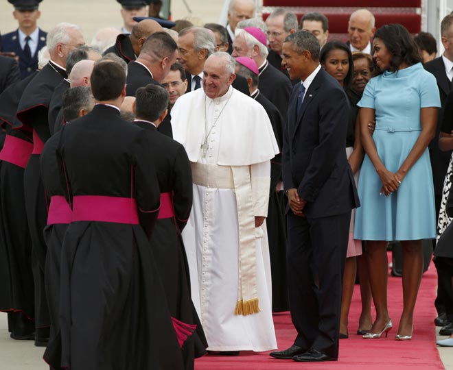 US President Barack Obama (right) welcomes Pope Francis to the United States as the Pontiff shakes hands with dignitaries upon his arrival at Joint Base Andrews outside Washington. — Reuters photo