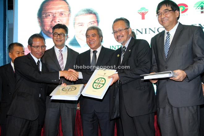 Sudarsono (third left) and Awang Tengah (third right) witness heads of agencies receiving a copy of the Inter-Agency Standard Operating Procedure for Performance of Forestry Function in Sarawak for Sarawak Timber Legality Verification. 