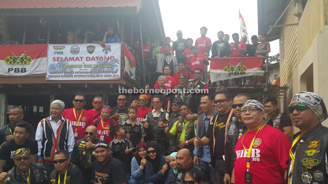 The bikers posing at the entrance of the longhouse at Kampung Benuk. 