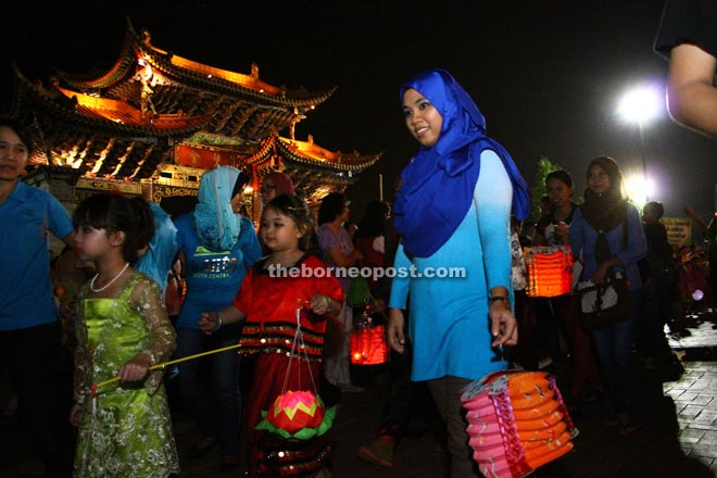 Both the young and adults happily participating in a lantern procession held during the event.