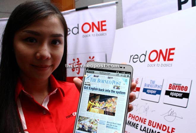 A RedONE staff member shows The Borneo Post’s e-paper on a tablet computer.