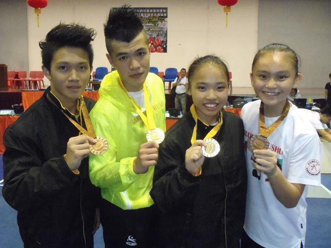 (From left) Sarawak’s Clement Thian Fung Seng, Clement Ting Su Wei, Lee Hui Xian and Fu Wen Jie posing with the medals they won on the first day of the 25th National Wushu Championship at SJK Chung Hua No. 3 Alumni Hall yesterday.