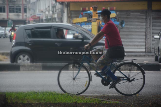 A cyclist wears a facemask to protect himself against haze.