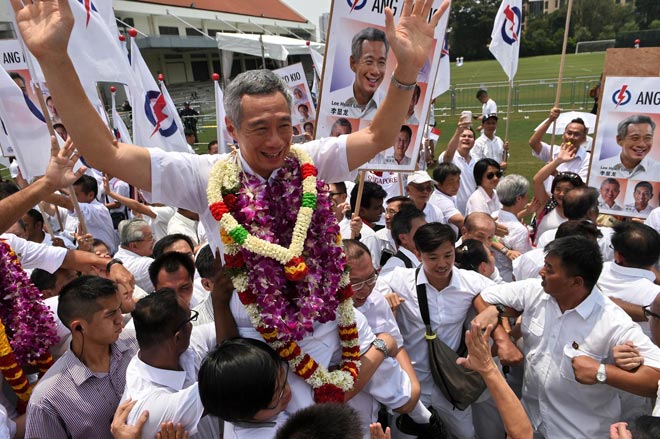 Lee Hsien Loong (centre) of the ruling People’s Action Party (PAP) gestures while carried by supporters after filing his candidacy documents at the nomination centre ahead of the general election in Singapore. — AFP photo