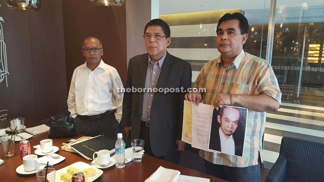 Kudhar (centre) flanked by his advisor, Datu Eddy Sulaiman (right), showing the photo of Kudhar’s late father, Julaspi, and a family tree explaining his relations with the Kiram lineage.