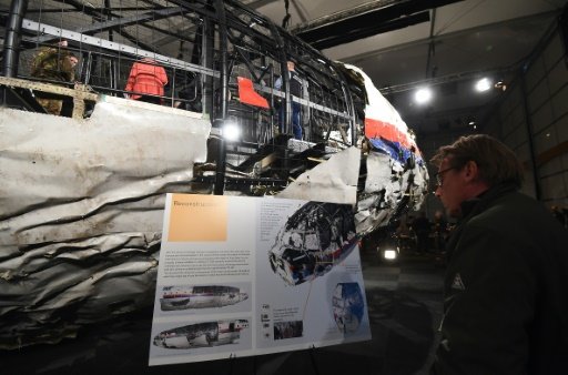 © AFP | The wrecked fuselage of Malaysia Airlines flight MH17 is presented to the press during a presentation of the final report on the cause of its crash, at the Gilze Rijen airbase October 13, 2015 