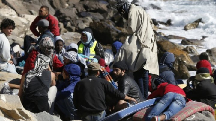 © AFP/File | Migrants wait on the rocks on the shoreline on September 30, 2015 at the French-Italian border in Ventimiglia 