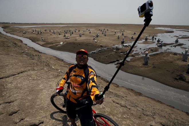 A cyclist takes a picture of himself at the Lapindo mud field in Sidoarjo. — Reuters photo