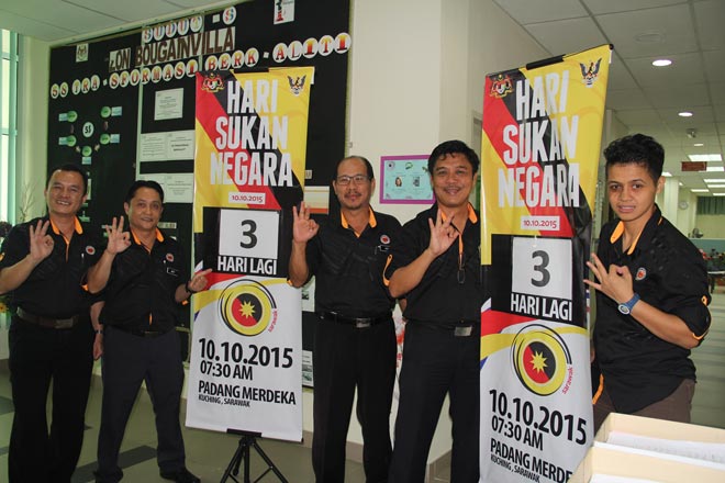 Harris (centre) and some of his staff displaying the posters after the press conference.
