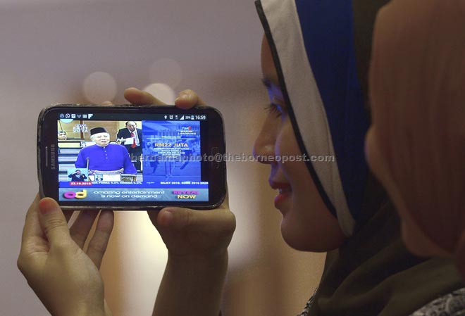 People watching the tabling of 2016 Budget by Prime Minister Datuk Seri Najib Tun Razak on their smartphones yesterday. — Bernama photo