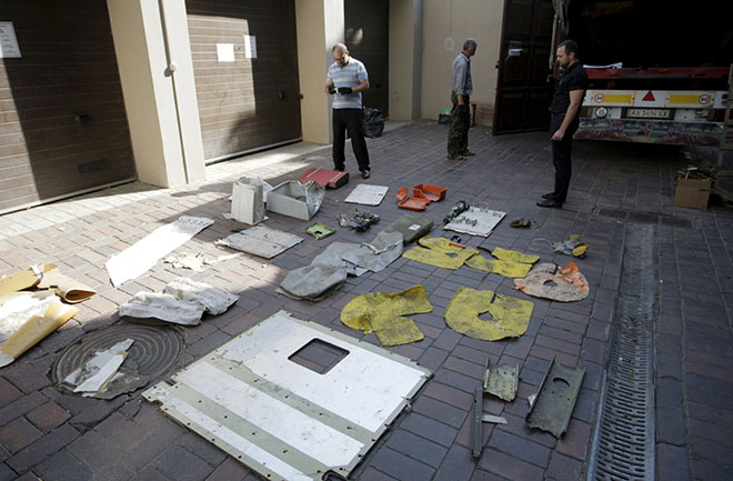 Local workers stand next to pieces of wreckage from a Malaysia Airlines Boeing 777 plane outside the Prosecutor General’s office in Donetsk, Ukraine, Sept 30 before the wreckage, believed to be from MH17,  were transferred to Dutch investigators. — Reuters file photo