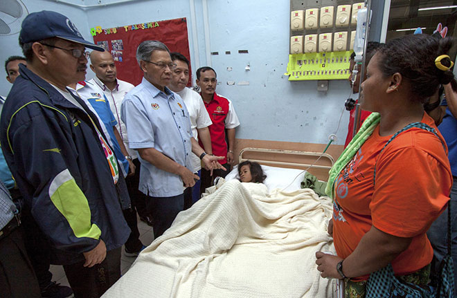 Minister of International Trade and Industry Datuk Seri Mustapa Mohamed (fourth left) speaks to Midah (right) during his visit to see Norieen at the hospital. — Bernama photo 