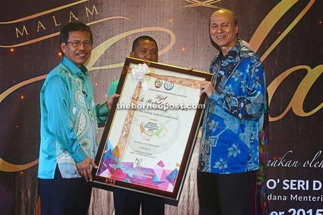 Dato’ Sri Alwi Ibrahim (right) presenting the Tokoh Pertubuhan Kebangsaan  award to Lee.