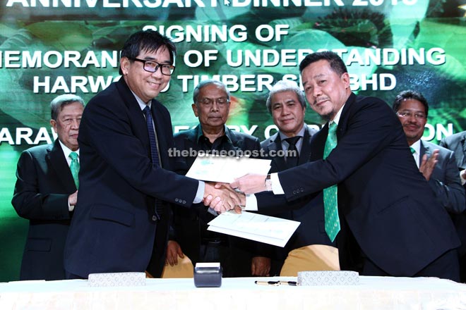 Wong (left) and Abdul Adi exchanging agreements after the MoU signing. Also seen from left are Bujang, Adenan and Awang Tengah.