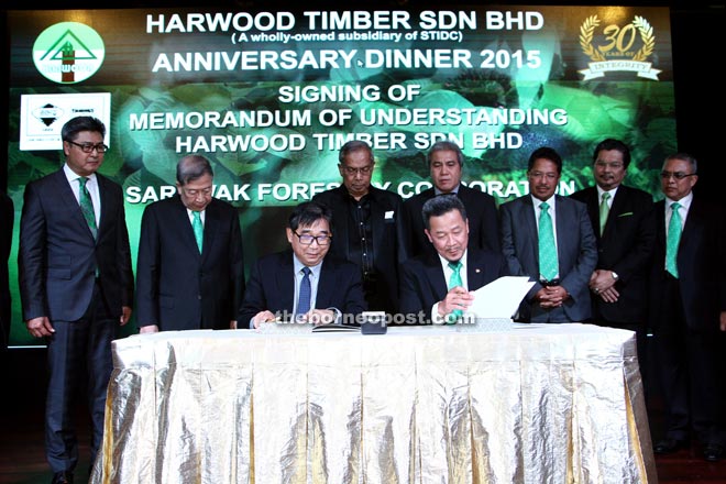 Wong (left) and Abdul Adi sign the MoU with Adenan (standing third left) and Bujang (second left) acting as witnesses. Also present on stage included Resource Planning and Environment Ministry permanent secretary Datu Sudarsono Osman (left), Awang Tengah (fourth left) and State deputy secretary Datu Misnu Taha (fifth left). — All photos by Chimon Upon