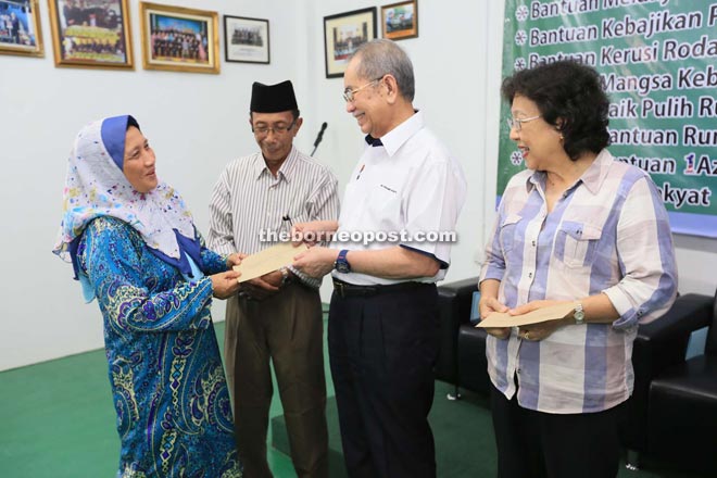 Wan Junaidi (second right) presents assistance to one of the recipients while Rashidi (left) and Feona look on. — Photo by Kong Jun Liong