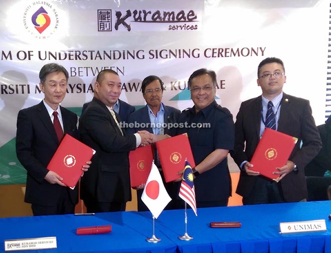 Kadim (second right) exchanging the signed MoU with Kenji, witnessed by Johari (right) and Shinya (left).