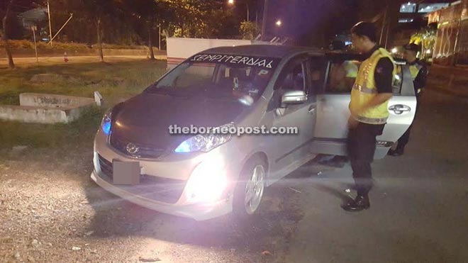 Police inspecting the suspects' Perodua Alza car during the roadblock along Jalan Tunku Abdul Rahman yesterday morning.