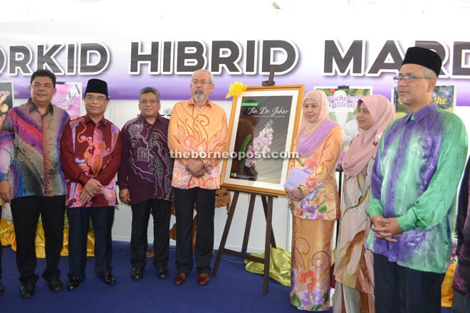 Juhar (fourth left), Norliday (third right), Yahya (second left), Tawfiq (right), Fadil (left) and others posse next to a picture of the 'Perreiraara Tun Dr Juhar’ orchid.