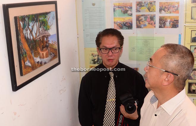 Rozman (right) is seen with the school’s visual arts teacher, Azize M Yusoph in the exhibition.