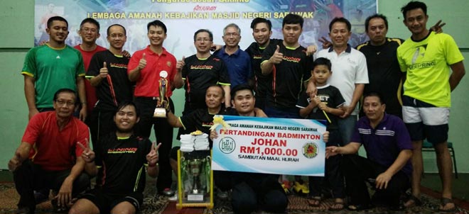 Masjid Darul Ihsan A players and officials celebrating their victory in the 7th Inter-Mosque and Surau Badminton Tournament after the prize presentation.