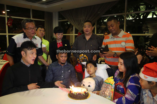 Aznil (left) and guests singing a birthday song to Muhammad Saiful. 