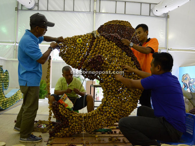 (From left) Sudin Narawi, Noh Bujang, Elcyrinzan Jamaian and Mohd Farid Mandli from Semenggok Agricultural Institute decorating a fish sculpture with ‘Asam Payak’ for HPPNK 2015. — Photo by Wilfred Pilo  