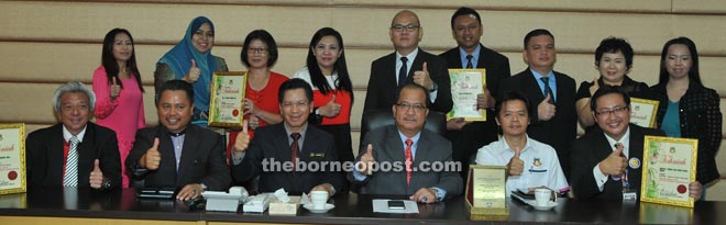 Mayor Datuk Abidin Madingkir (third right) presenting appreciation certificates to the winners of the 1Malaysia National Level Clean Toilets Award 2015 at City Hall yesterday. They are Dr Tan Bee Hwai of Women and Children Hospital Sabah (back row, third left), Carriek Chong of Imago (seated right), Johnson Koh of Oceanus Waterfront Mall (seated left), Shelly Lee Eun Joung of Restoran Deli Korea (standing second right).