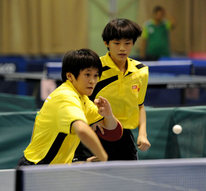 Selangor’s Sammy Tay (right) watches as teammate Kuan E Xuan hits a shot to Sabah’s Loh Qiao Ni and Zoe Fong Yi Chong in the Girls’ U13 doubles final. Selangor won 3-1. — Photo by Chai Chang Yu