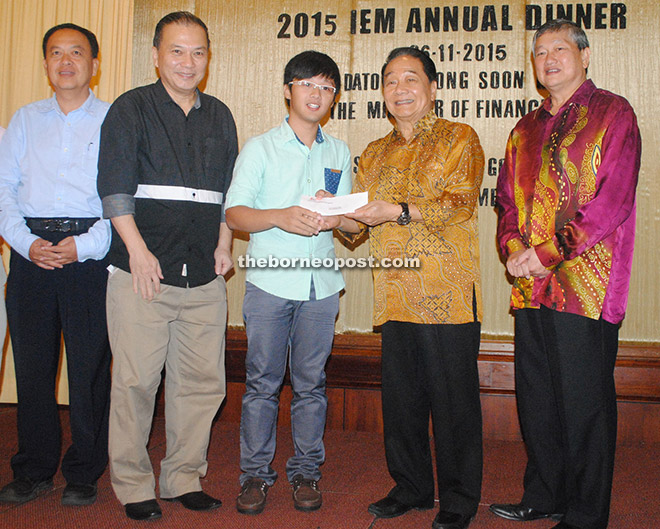 Wong (second right) presents incentive to Ting Huong Hun for being the best student of University College of Technology Sarawak (UCTS) while others look on.