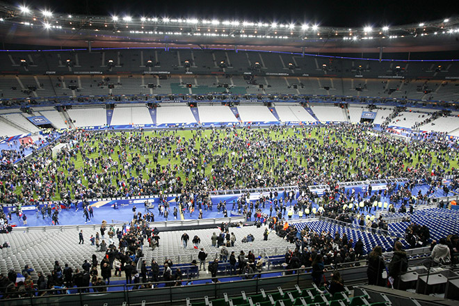 Spectators wait on the pitch of the Stade de France stadium in Seine-Saint-Denis after a series of gun attacks occurred across Paris as well as explosions outside the national stadium where France was hosting Germany. — AFP photo