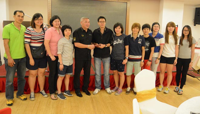 Women’s team captain Bong Yik Kee receives the incentives from contingent leader Simon Wong (fifth left) as the team members and coach Ong Seng Huat (left) look on.