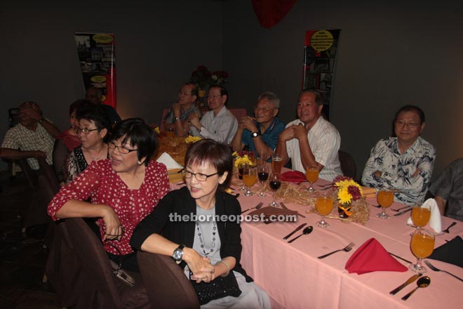 Wong (seated front right) and other guests observing performances by their ex-classmates during the karaoke session.