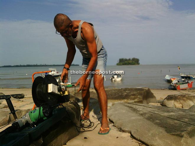 Piruz uses his tools to fix his fishing equipment by his seaside home at Kampung Pasir Pandak.