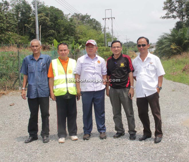 Martin (middle) with some local PBB members and Public Works Department representatives during a working visit to check on the progress of road widening project at Mentung Mubuk.
