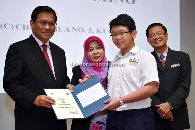 Dr Abdul Rahman (left) and Rakayah (second left) presenting Chew Wai Ming of SJK(C) Chung Hua No.3 with his UPSR result and certificate while Su looks on. - Photo by Tan Song Wei