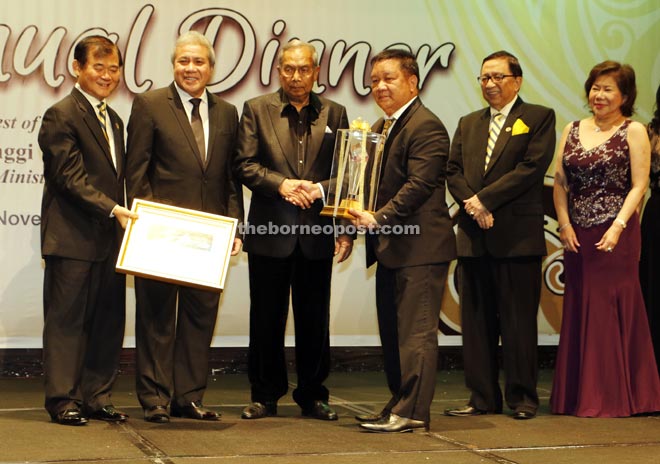 Adenan (third left) shakes hands with Balan after handing out the award. Seen from right are Liew, Karim, Awang Tengah and Ting. — Photos by Chimon Upon