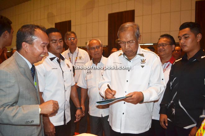 Adenan signs the Bukit Mabong souvenir book after the ceremony to declare Bukit Mabong as a district.